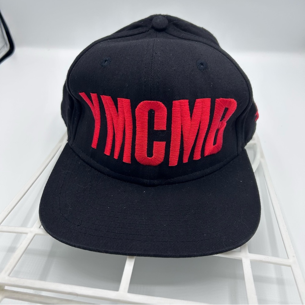 Black Snapback Hat with Red YMCMB Embroidery on front.